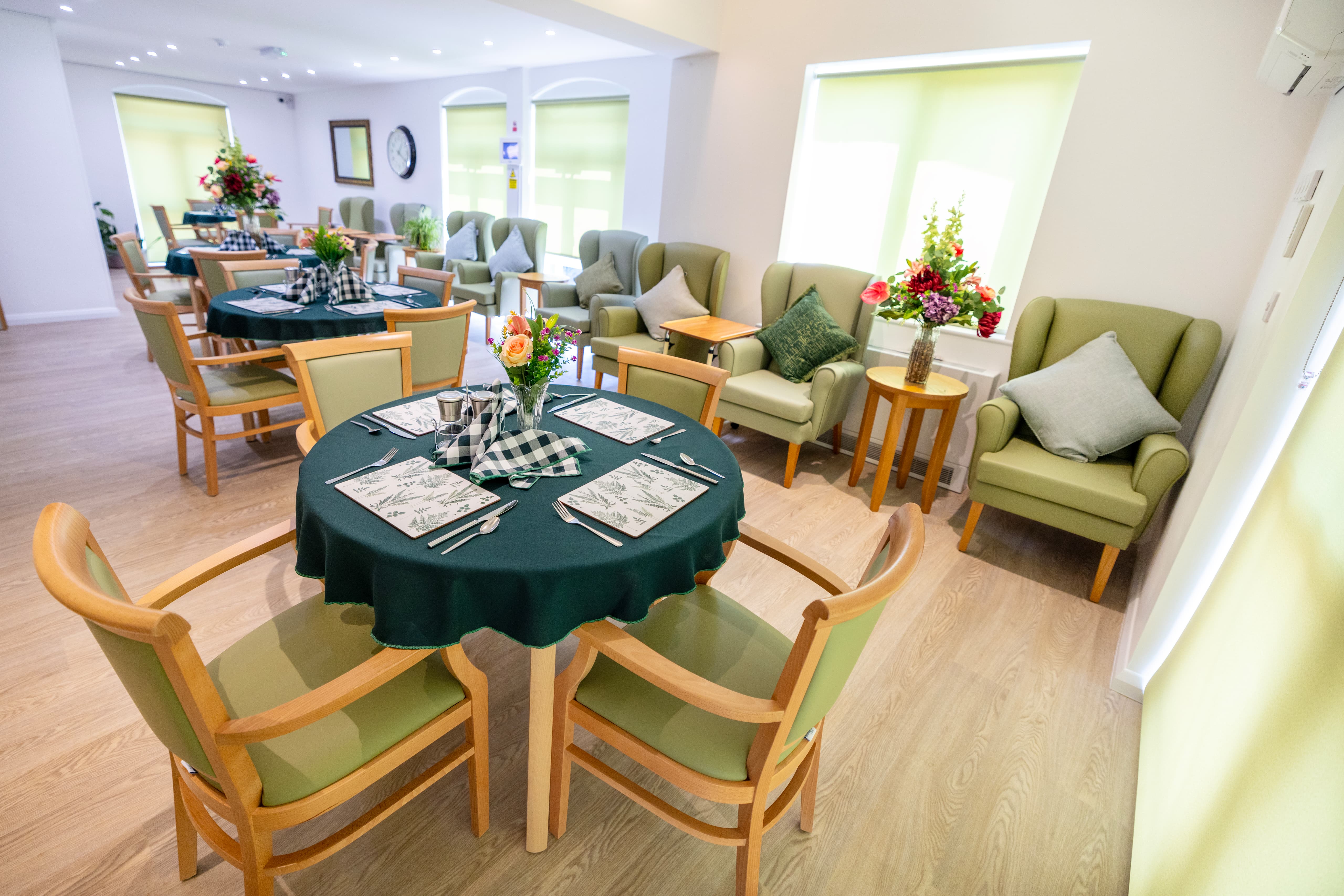 Comprehensive view of dining area with botanical placemats and fresh flowers