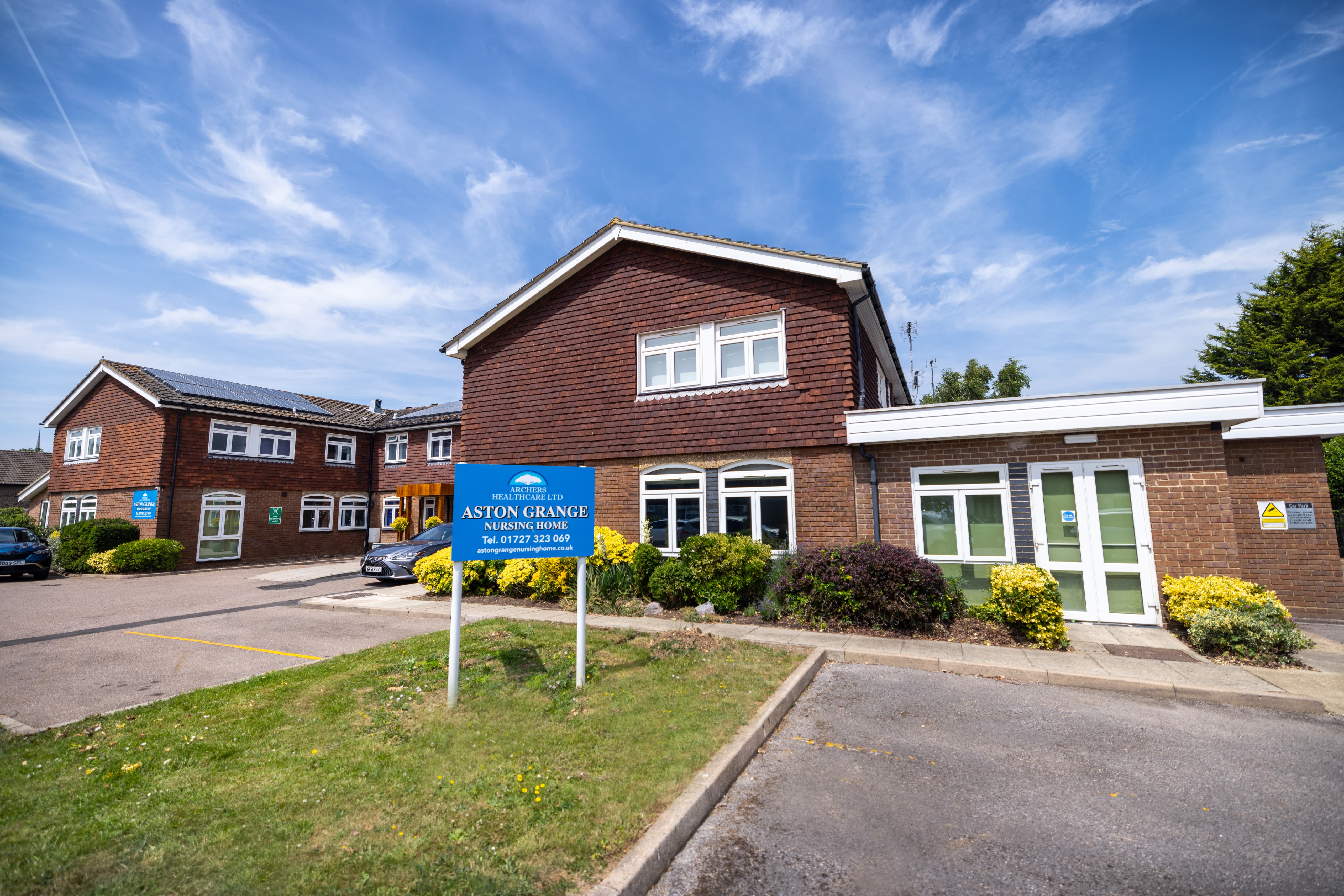 Main exterior view of Aston Grange Nursing Home with blue signage