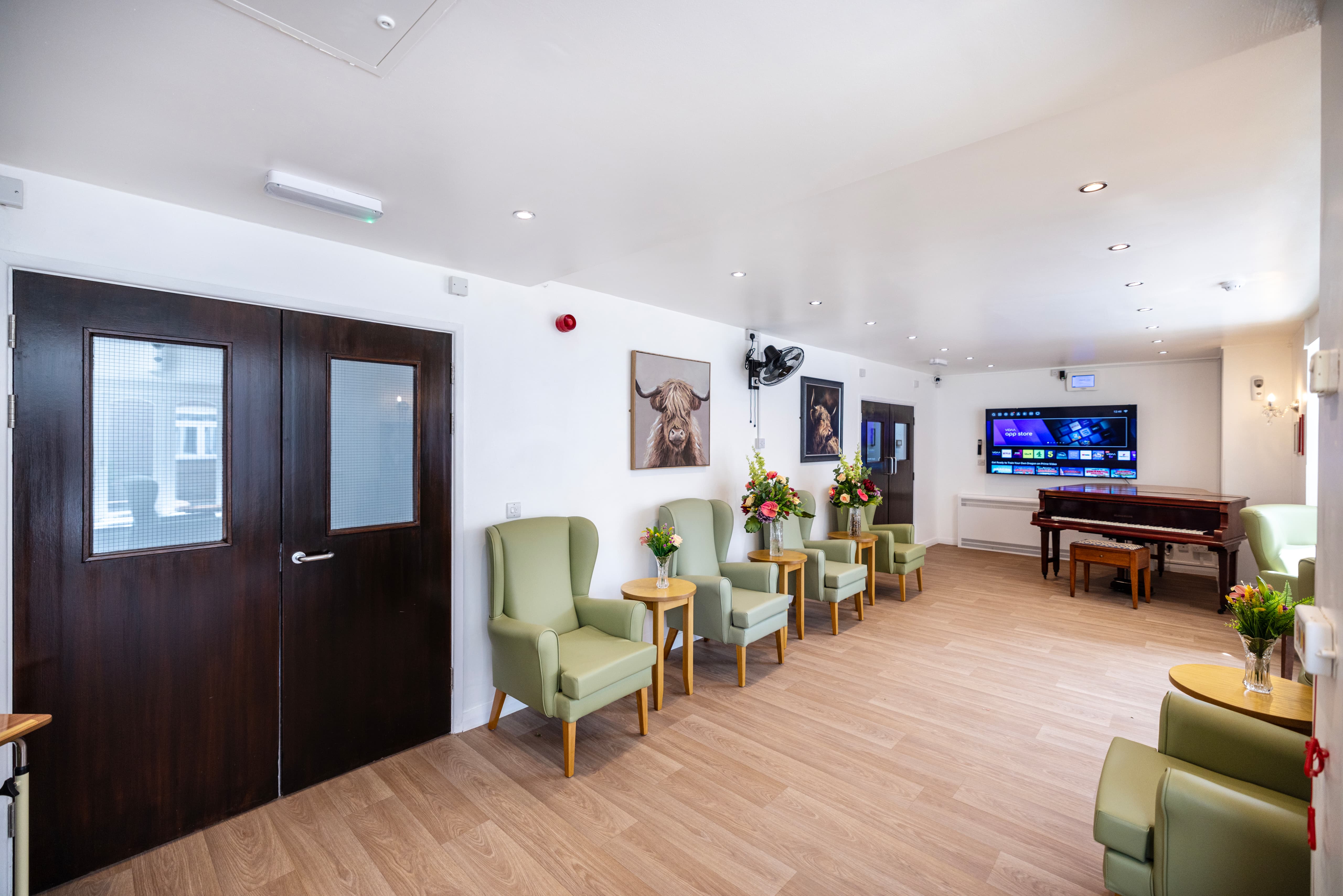 Main lounge with sage green furniture and Highland cattle artwork