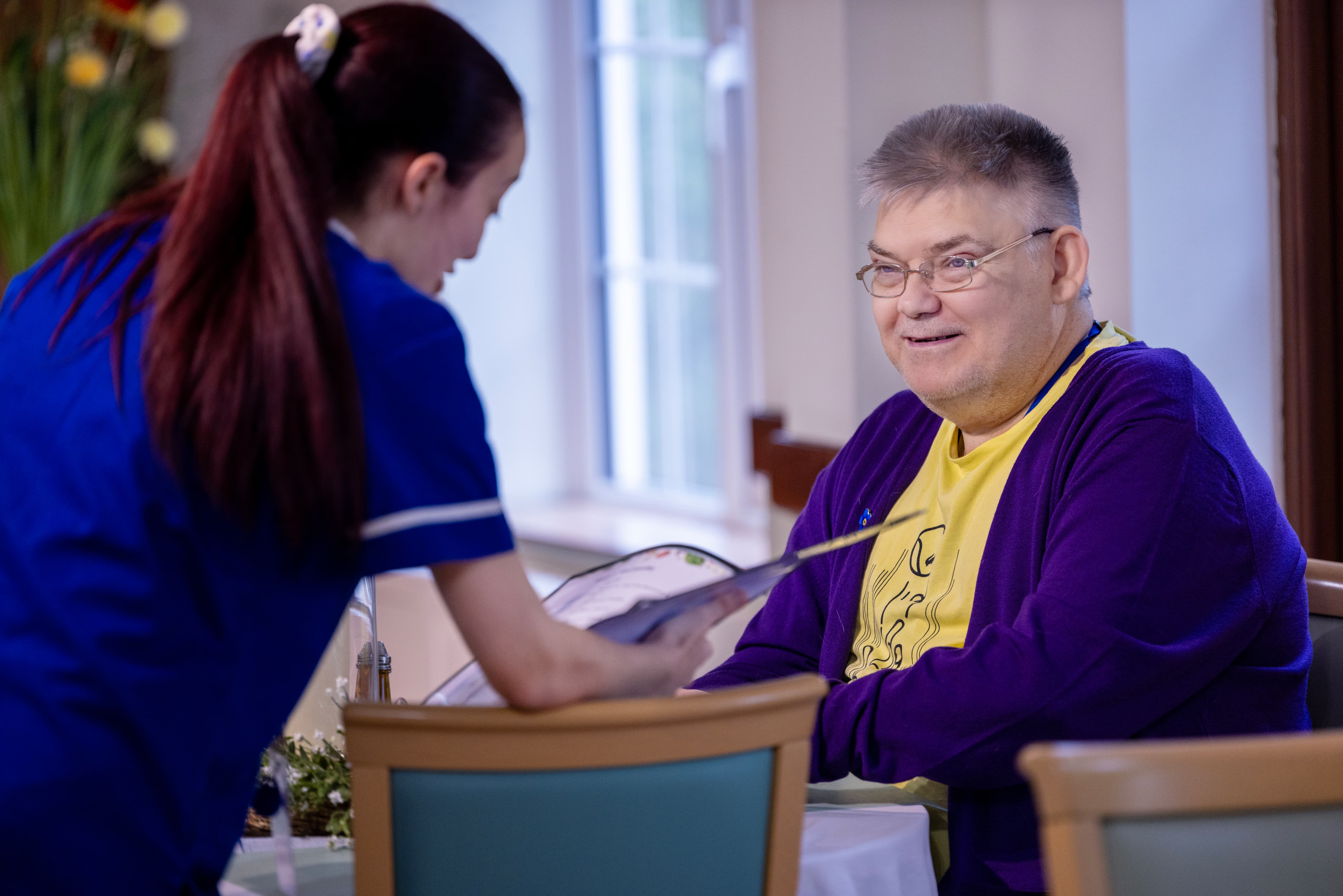 Care worker using technology to engage with resident