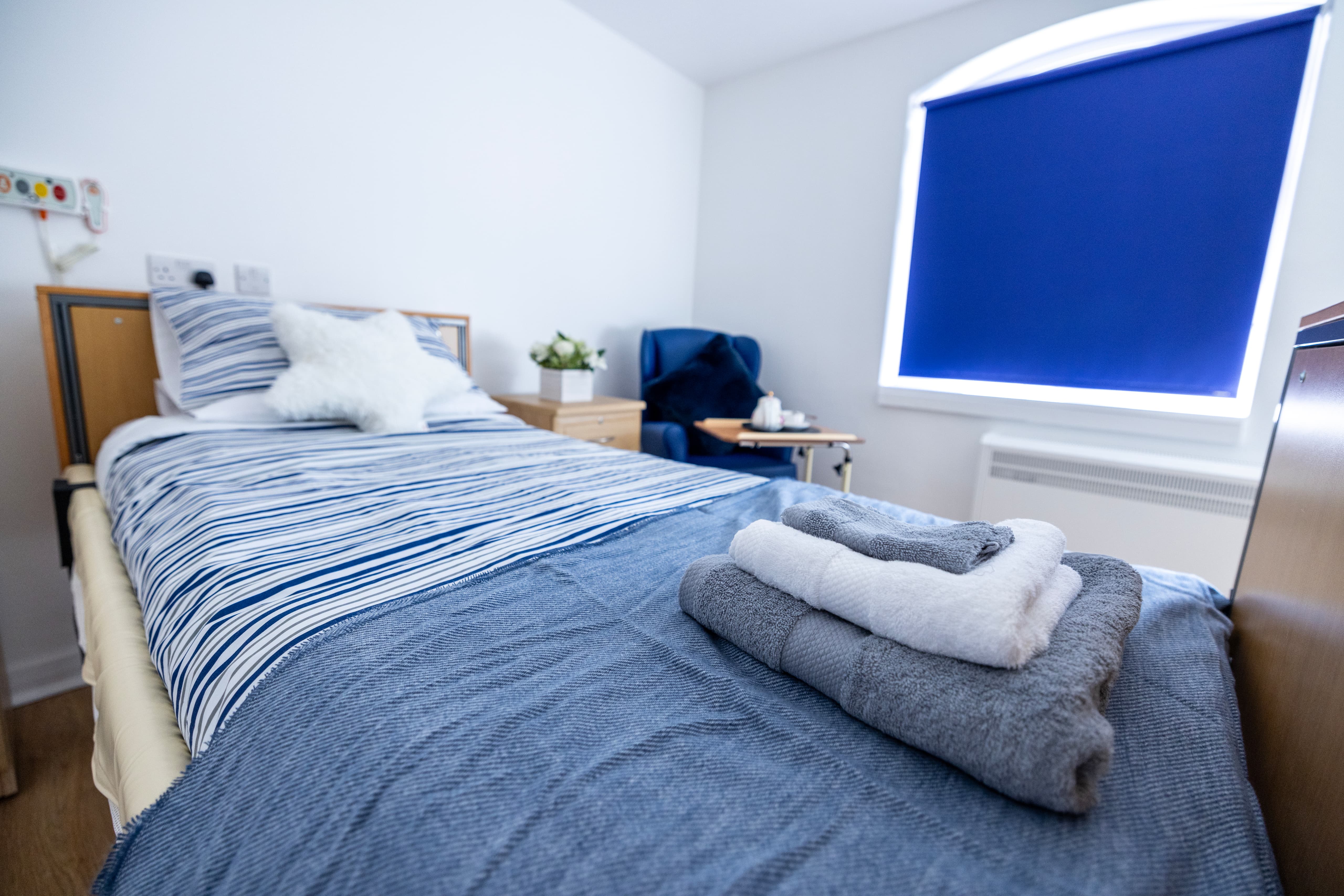 Comfortable resident bedroom with modern furnishings and blue accents